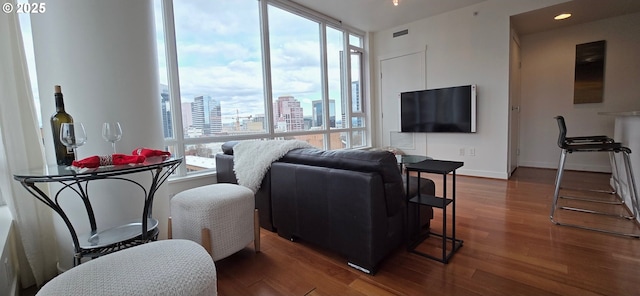 living area featuring visible vents, recessed lighting, baseboards, and wood finished floors