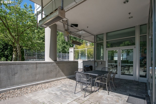 view of patio with outdoor dining space, french doors, and fence