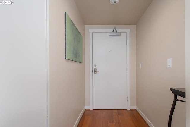 doorway to outside with light wood-style flooring and baseboards