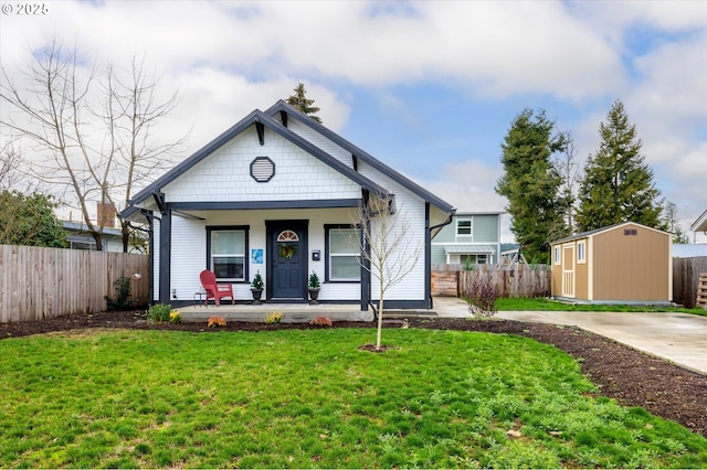 view of front facade with a shed, a front lawn, and covered porch