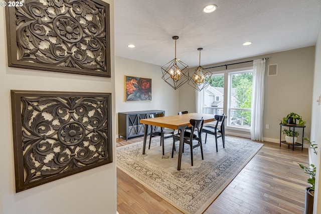 dining area with wood-type flooring, baseboards, recessed lighting, and a chandelier