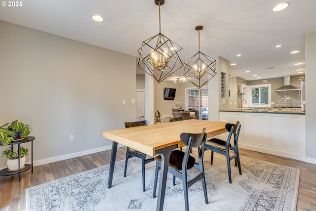 dining room featuring light wood-style flooring, a chandelier, recessed lighting, and baseboards