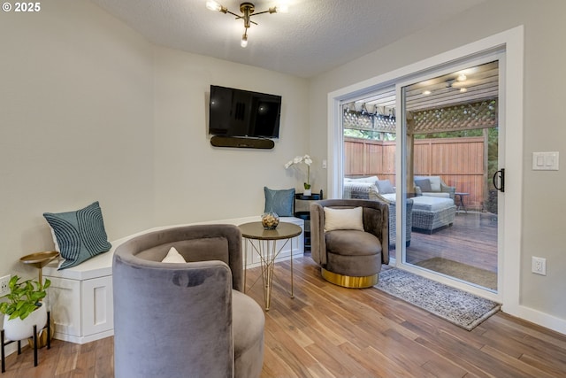 sitting room featuring wood finished floors, a textured ceiling, and baseboards