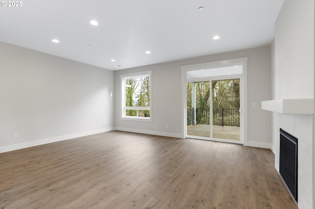 unfurnished living room featuring a fireplace and light hardwood / wood-style floors