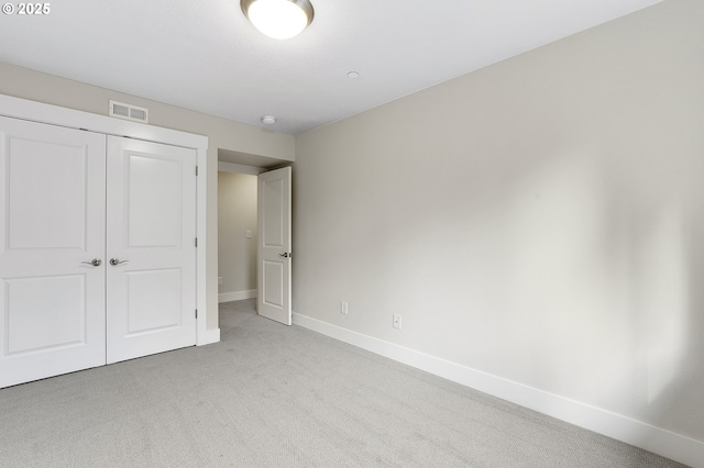 unfurnished bedroom with a closet and light carpet