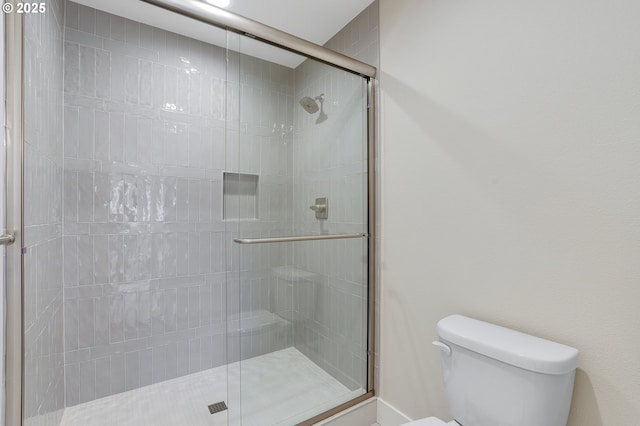 bathroom featuring an enclosed shower and toilet