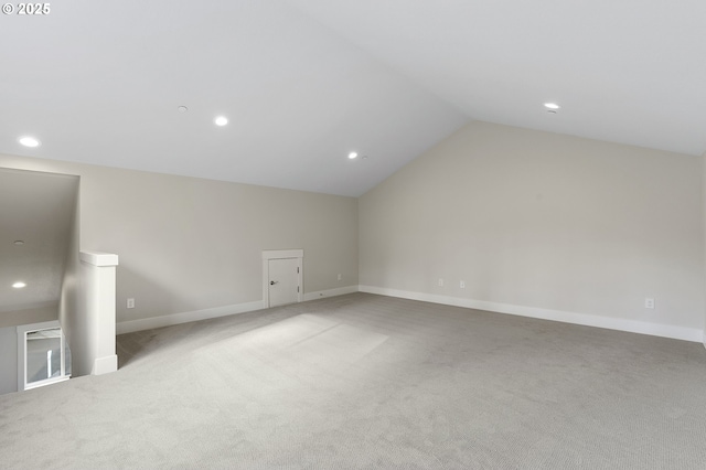 bonus room with lofted ceiling and light carpet