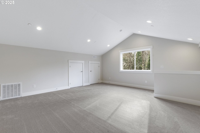 additional living space featuring vaulted ceiling and light carpet