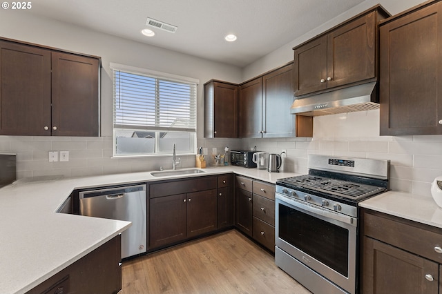 9465 N Alder St, Camas, WA 98607 - kitchen featuring appliances with stainless steel finishes, extractor fan, dark brown cabinetry, light countertops, and recessed lighting