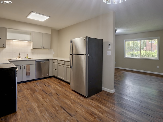 1818 E 32nd St, Vancouver, WA 98663 - kitchen with appliances with stainless steel finishes, dark wood finished floors, tasteful backsplash, and light countertops