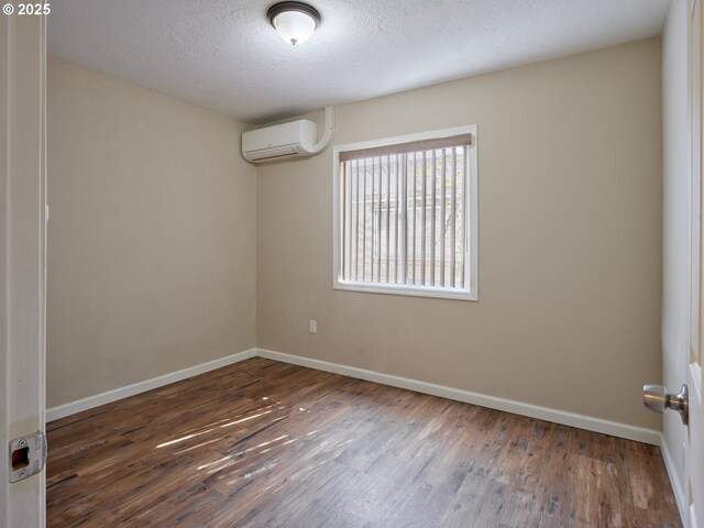 1818 E 32nd St, Vancouver, WA 98663 - spare room with wood finished floors, an AC wall unit, and a textured ceiling