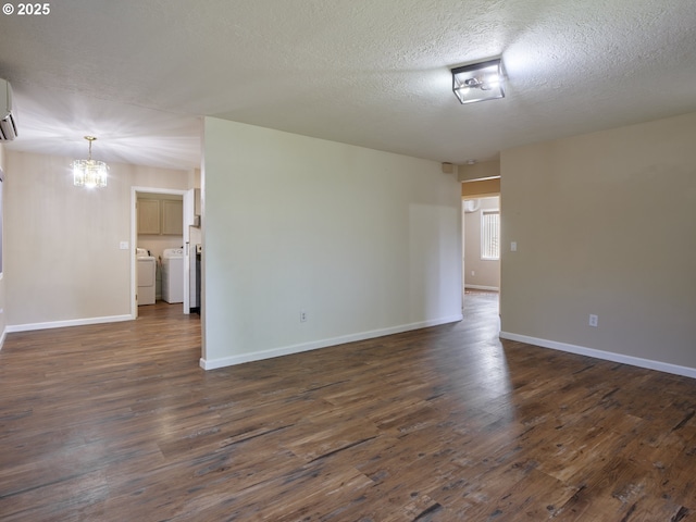 1818 E 32nd St, Vancouver, WA 98663 - unfurnished room featuring a chandelier, washer and dryer, dark wood-type flooring, a textured ceiling, and an AC wall unit