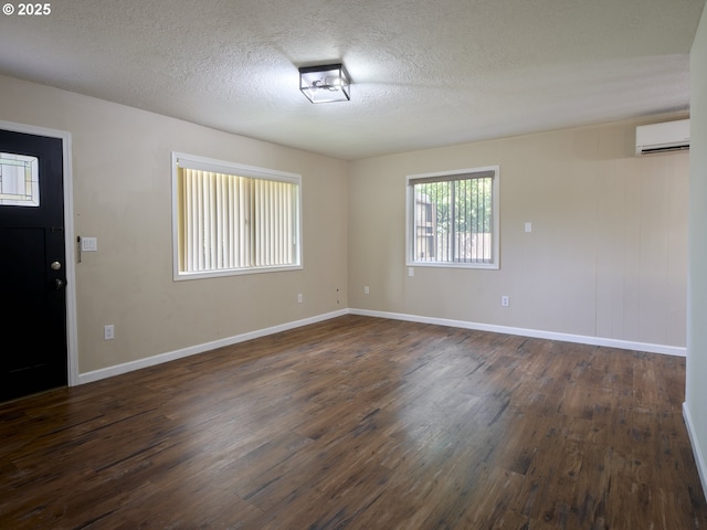 1818 E 32nd St, Vancouver, WA 98663 - unfurnished room with a wall mounted air conditioner, dark wood-type flooring, and a textured ceiling