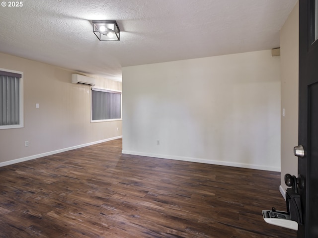 1818 E 32nd St, Vancouver, WA 98663 - spare room with a wall unit AC, dark wood finished floors, and a textured ceiling