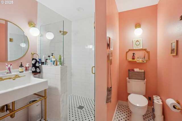 full bathroom featuring a shower stall, toilet, and baseboards
