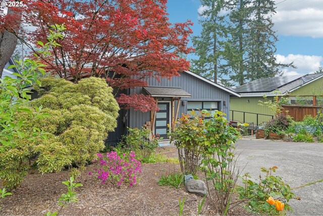 view of front of house with a garage, fence, and asphalt driveway
