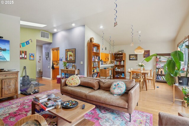 living area with recessed lighting, light wood-style flooring, and high vaulted ceiling
