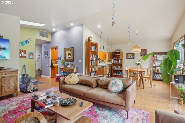 living room with light wood-style floors, recessed lighting, and high vaulted ceiling