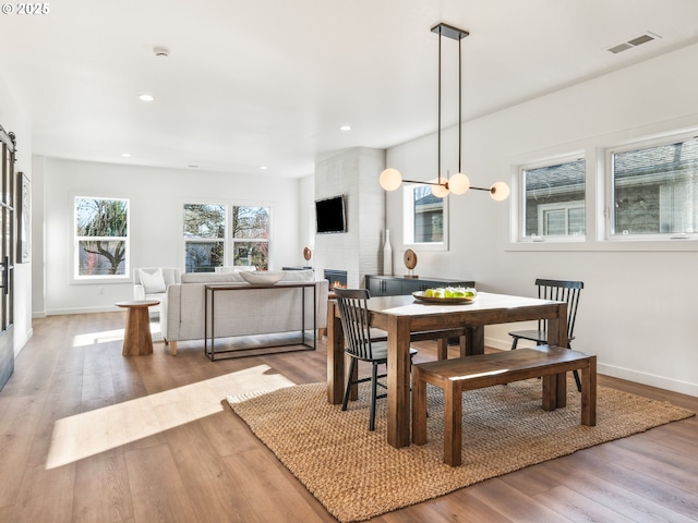 dining space featuring hardwood / wood-style flooring and a fireplace