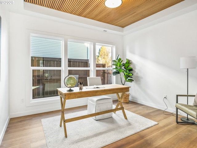 office with light hardwood / wood-style flooring, wooden ceiling, and a raised ceiling