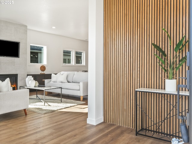 living room with hardwood / wood-style flooring and a large fireplace