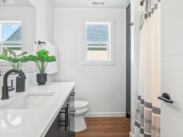 bathroom with hardwood / wood-style flooring, vanity, and toilet