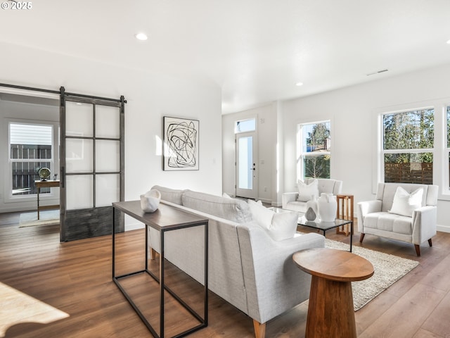 living room with hardwood / wood-style flooring and a barn door