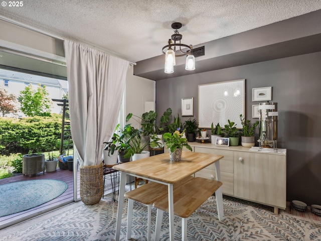 dining room featuring a chandelier and a textured ceiling