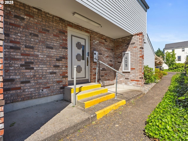 view of exterior entry with brick siding