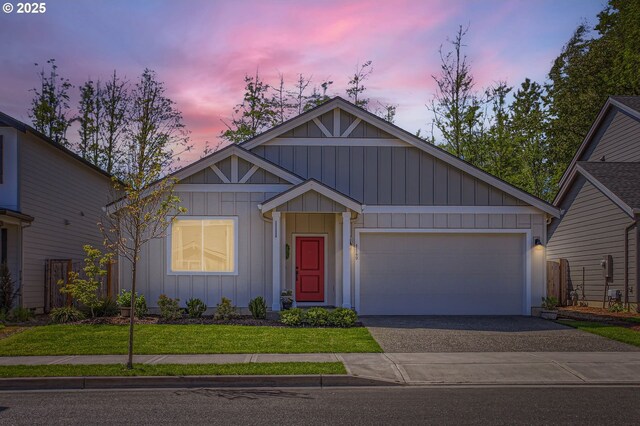 view of front of house featuring board and batten siding, driveway, an attached garage, and a front yard