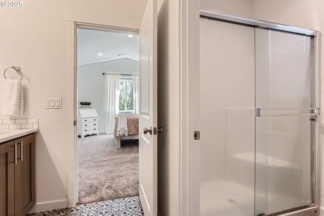 ensuite bathroom featuring lofted ceiling, a stall shower, vanity, baseboards, and recessed lighting