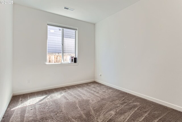 carpeted spare room featuring baseboards