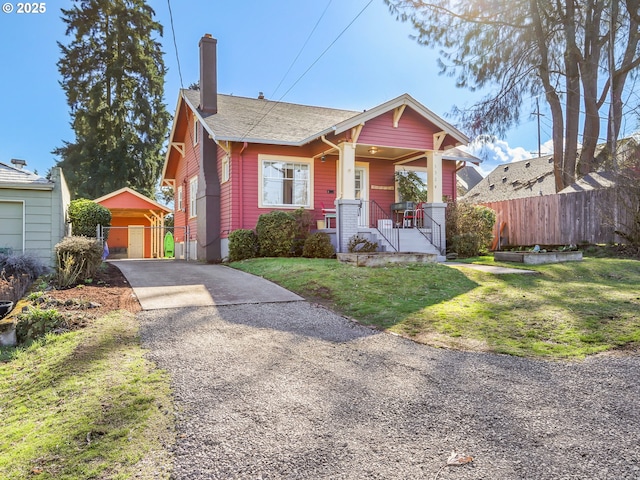 bungalow-style home featuring a chimney, covered porch, fence, driveway, and a front lawn