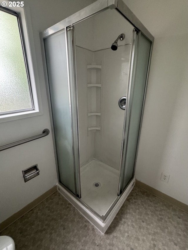 full bath featuring a stall shower and baseboards