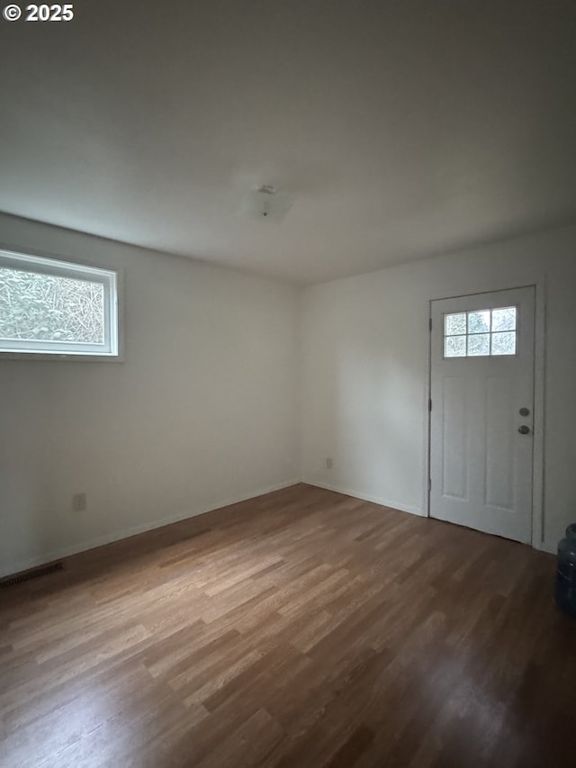 foyer with visible vents, baseboards, and wood finished floors