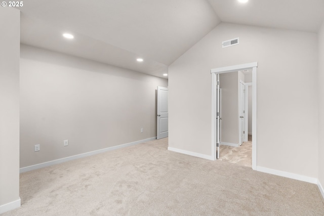 unfurnished bedroom featuring light colored carpet and vaulted ceiling