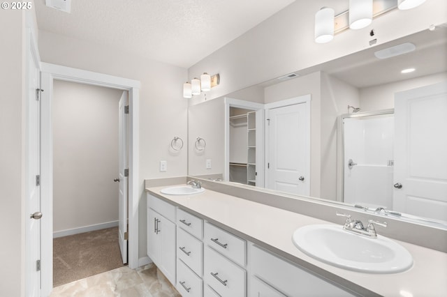 bathroom featuring vanity, an enclosed shower, and a textured ceiling