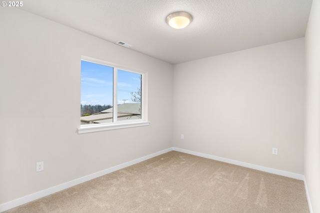 carpeted spare room with a textured ceiling