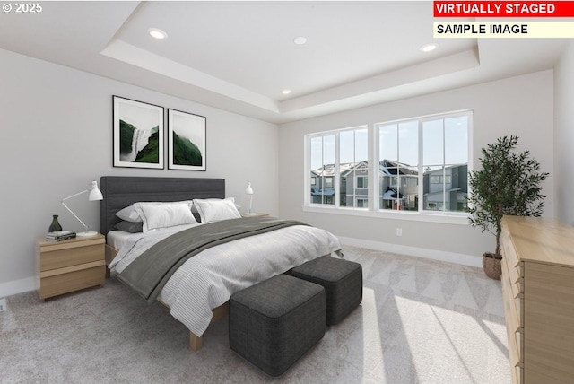 carpeted bedroom featuring a tray ceiling