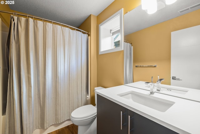 bathroom with vanity, toilet, hardwood / wood-style floors, and a textured ceiling