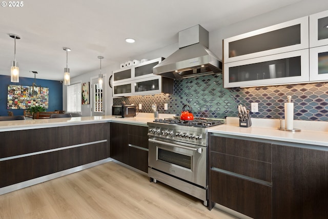301 S 18th St, La Grande, OR 97850 - kitchen featuring high end range, wall chimney range hood, dark brown cabinetry, light countertops, and recessed lighting