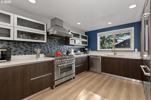 301 S 18th St, La Grande, OR 97850 - kitchen featuring appliances with stainless steel finishes, wall chimney range hood, a sink, light countertops, and modern cabinets