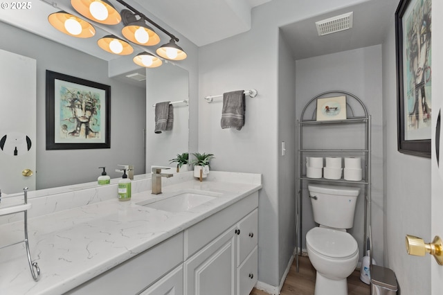 301 S 18th St, La Grande, OR 97850 - bathroom featuring wood finished floors, toilet, vanity, and baseboards