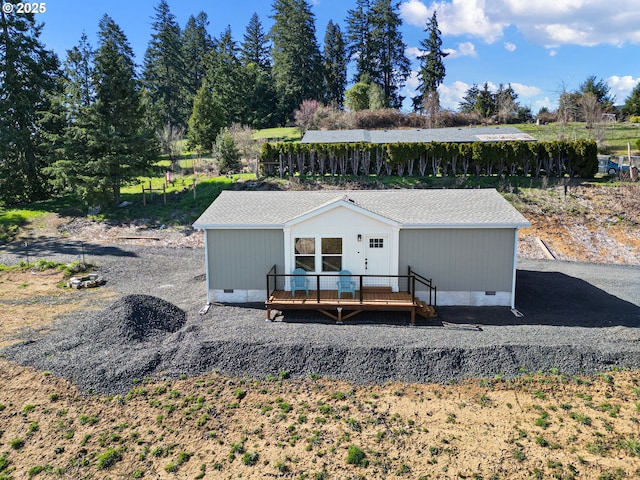 back of house with crawl space, a deck, and a shingled roof