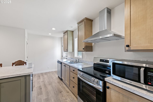 kitchen featuring light wood-style flooring, appliances with stainless steel finishes, light countertops, and wall chimney range hood