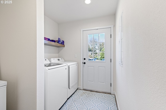 washroom featuring baseboards, laundry area, and washing machine and clothes dryer