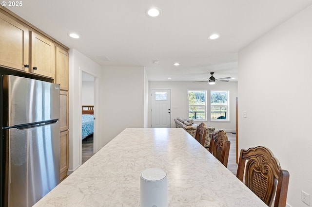 kitchen with a ceiling fan, light brown cabinetry, wood finished floors, freestanding refrigerator, and recessed lighting