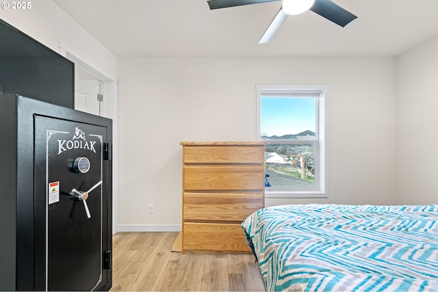 bedroom featuring ceiling fan, baseboards, and light wood-style flooring