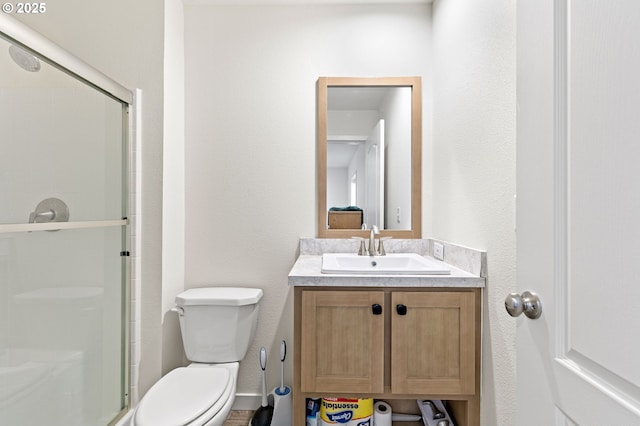 bathroom with vanity, toilet, and a shower stall