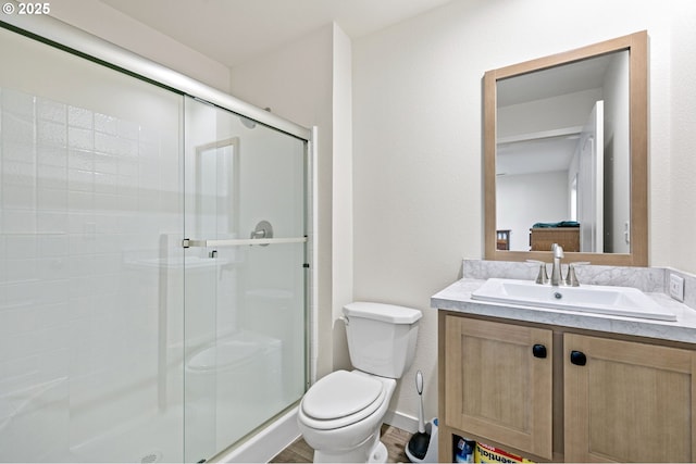 full bath with vanity, toilet, baseboards, and a stall shower